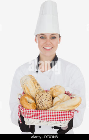 Happy young chef holding bread basket Stock Photo