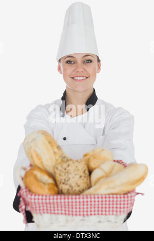 Happy young female chef with bread basket Stock Photo