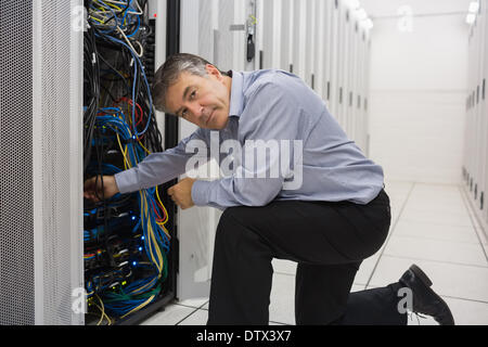 Technician kneeling and repairing a server Stock Photo