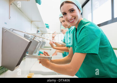 Surgeons washing their hands while smiling Stock Photo