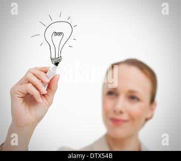 Woman drawing bulb with marker Stock Photo