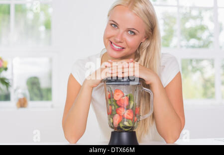 Smiling woman putting hands on the mixer Stock Photo