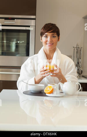 Woman in bathrobe having healthy breakfast
