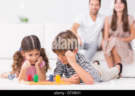 Siblings playing board game on the floor Stock Photo
