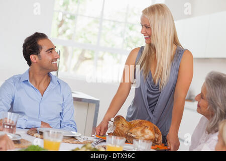 Happy wife bringing turkey to the table Stock Photo