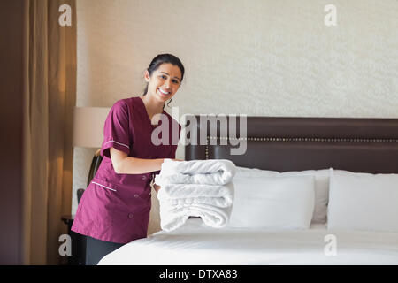 Happy maid working in hotel room Stock Photo