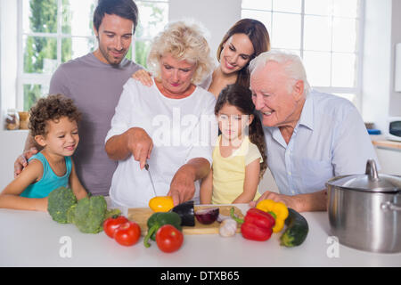 Happy family cutting vegetables together Stock Photo