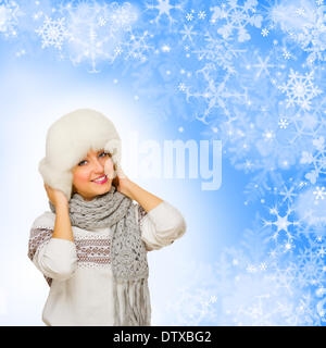 Young girl in fur hat on winter background Stock Photo