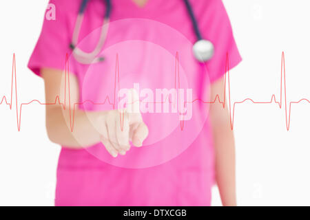 Nurse in pink scrubs touching red ECG line Stock Photo