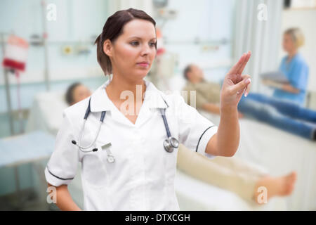 Nurse pressing on invisible screen Stock Photo