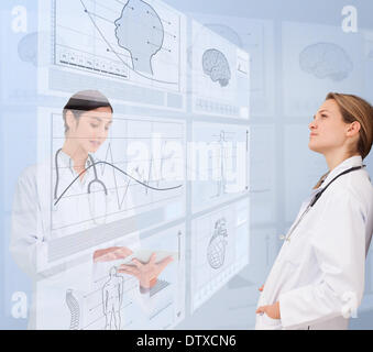 Women doctors using futuristic interfaces Stock Photo