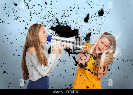 Girl shouting at another through megaphone Stock Photo