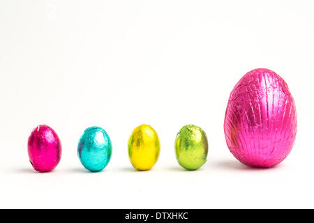 Four small easter eggs beside large one Stock Photo