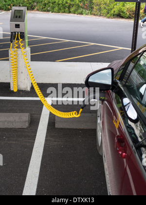 Charging an Electric Car. A plug-in Chevrolet Volt car plugged into a parking-lot charging station. Stock Photo