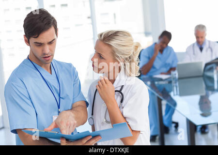 Two doctors talking about a blue file Stock Photo