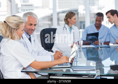 Two smiling doctors using laptop Stock Photo