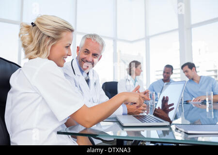 Two smiling doctors looking at a laptop Stock Photo