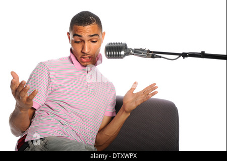 Young African American singing into vintage microphone isolated over white background Stock Photo