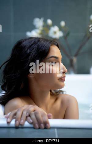 Hispanic woman relaxing in bath Stock Photo
