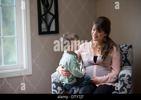 Pregnant Caucasian mother sitting with son Stock Photo