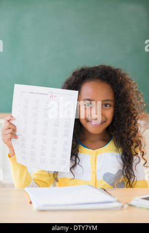 Mixed race student showing off A plus grade in classroom Stock Photo