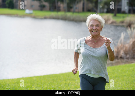 Senior Caucasian woman jogging in park Stock Photo