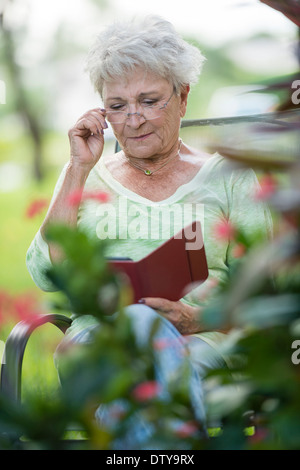 Senior Caucasian woman using digital tablet outdoors Stock Photo