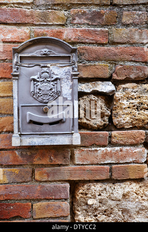 A letter box on a brick wall in Bagno Vignoni, Tuscany, Toscana, Italy Stock Photo