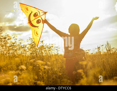 Caucasian mother and son flying kite in rural field Stock Photo