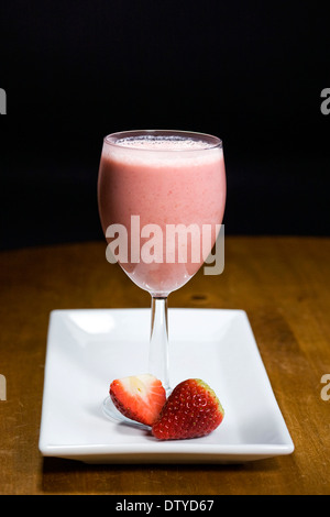 Strawberry smoothie and fruits on a white plate. Stock Photo
