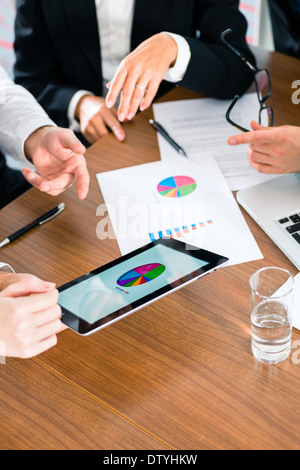 Business - banker, Manager or expert in meeting evaluates the figures on tablet computer Stock Photo