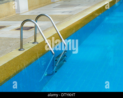 Grab bars ladder in swimming pool in daylight Stock Photo