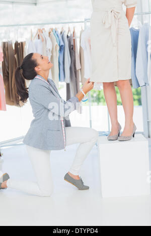 Pretty fashion designer adjusting dress Stock Photo - Alamy