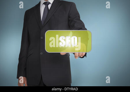 Businessman touching green tag with the word seo written on it Stock Photo