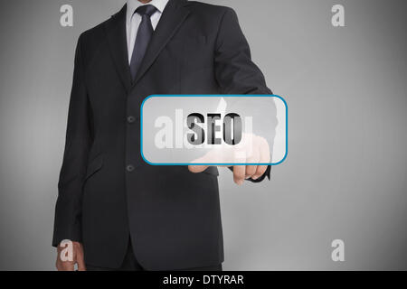 Businessman touching white tag with the word seo written on it Stock Photo