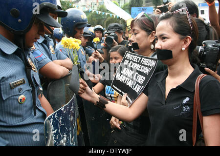 Manila, Philippine, . 25th Feb, 2014. Protesters offering flowers to the police during the Black Tuesday protest at the Edsa Shrine in Quezon City. -- Different media groups, together with student activists, commemorated the 28th anniversary of the Edsa Revolution with a protest rally against the Cybercrime Law. Credit:  J Gerard Seguia/NurPhoto/ZUMAPRESS.com/Alamy Live News Stock Photo