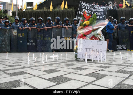 Manila, Philippine, . 25th Feb, 2014. A bouquet of flowers and lighted candles were placed by the protesters infront of the Edsa Shrine during the Black Tuesday demonstration, to symbolize the alleged death of internet freedom because of the enactment of the Cybercrime Law. -- Different media groups, together with student activists, commemorated the 28th anniversary of the Edsa Revolution with a protest rally against the Cybercrime Law. Credit:  J Gerard Seguia/NurPhoto/ZUMAPRESS.com/Alamy Live News Stock Photo