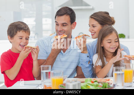 Happy family eating pizza slices Stock Photo