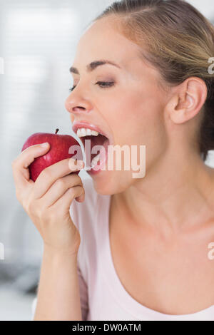 Pretty woman munching apple in close up Stock Photo