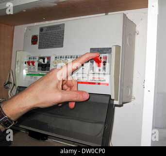 Switching off main electrical switch at distribution board Stock Photo