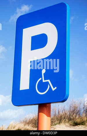 Close up of blue parking sign for disabled people in wheelchair at car park Stock Photo