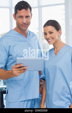 Smiling surgeons working together on tablet Stock Photo
