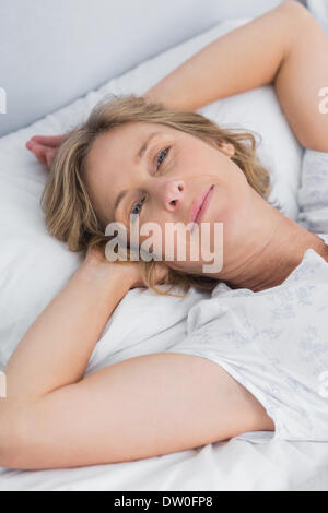 Woman lying peacefully in bed Stock Photo