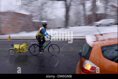 Washington DC, USA. 25th Feb, 2014. A man rides a bicycle during a heavy snowfall in Arlington, Virginian, the United States, Feb. 25, 2014. Credit:  Yin Bogu/Xinhua/Alamy Live News Stock Photo