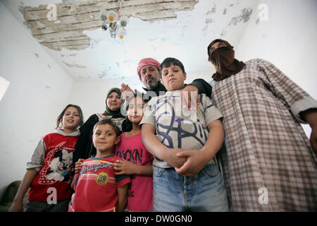 Feb. 21, 2014 - Al-Kitteh, Jarash, Jordan - Ahmad Mansour, 54, with his family pose for a picture at his house in the village of al-Kitteh western city of Jerash, 50 km northern the Jordanian capital Amman on February 21, 2014 . Mansour arrived on foot on a stretcher as a Syrian refugee to Jordan one year ago after he was wounded in his left hand and his back by a mortar shell landed on his house in Daraa, followed by his wife and his twelve children after three months (Credit Image: © Ahmad Abdo/APA Images/ZUMAPRESS.com) Stock Photo