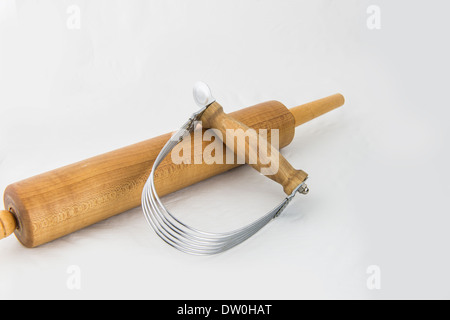 Two kitchen appliances used in the making of pie cruist. A pastry blender, and a rolling pin, isolated on white. Stock Photo