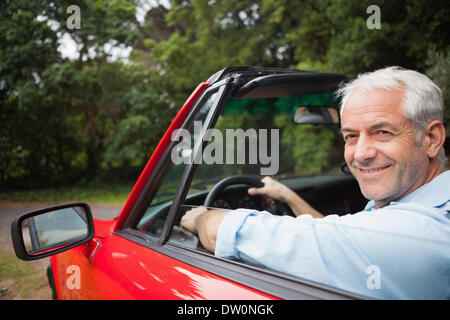 Smiling handsome man driving red cabriolet Stock Photo