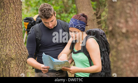 Fit couple reading map in a forest Stock Photo