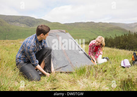 Happy couple pitching their tent Stock Photo