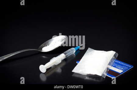 heroin spoon with syringe on black table Stock Photo